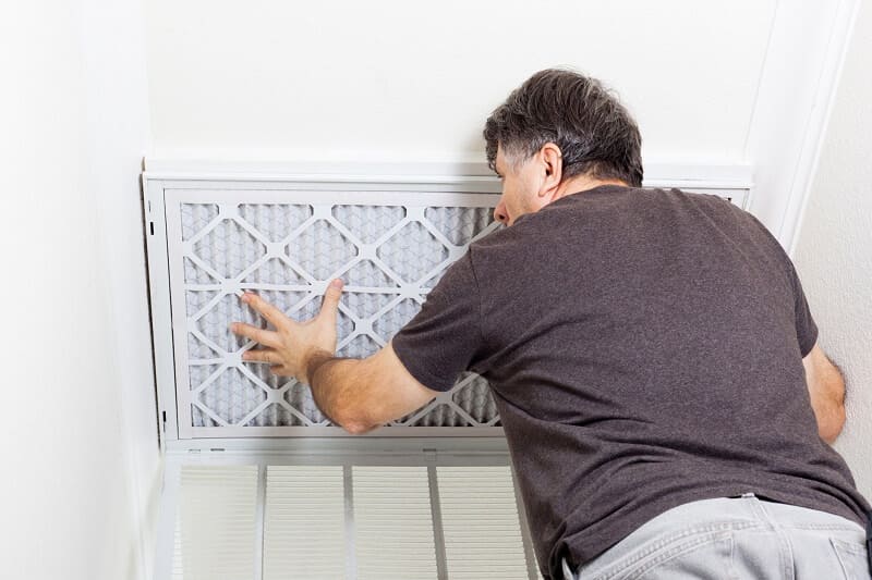 An experienced technician replacing an HVAC filter for a residential home in Pasadena, MD